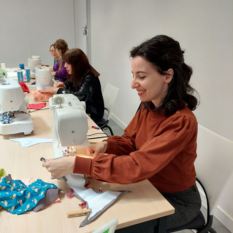 Clara Martinez, directrice de la Fondation, utilise une machine à coudre dans le cadre de l’atelier de confection de protections hygiéniques réutilisables.