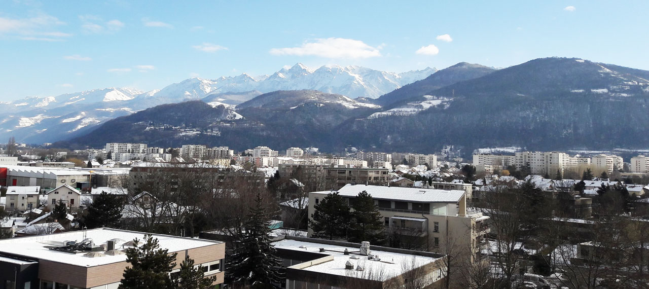 Vue des quartiers sud de Grenoble avec les montagnes en arrière-plan.