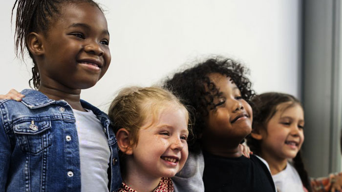 Groupe d’enfants souriants. Le groupe est composé d’enfant d’origines ethniques variées.