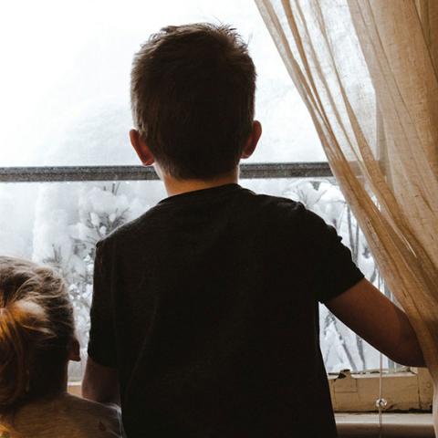 2 enfants de dos qui regardent par la fenêtre