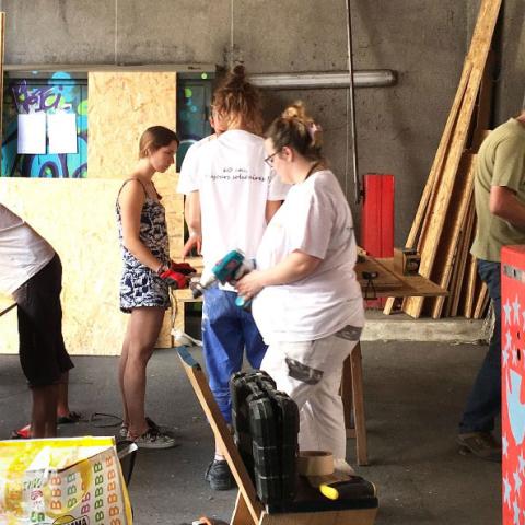 Un groupe d’une dizaine de personnes réalise des travaux de rénovation d’un logement. Ils travaillent par groupe de deux ou trois. 