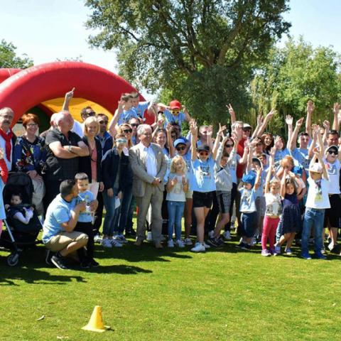 Portrait de groupe de membres de l’association Autisme 66 Espéranza, adultes et enfants, tous ensembles sur un terrain de golf. 