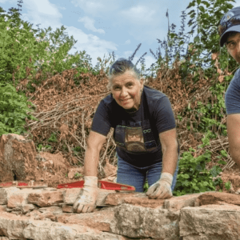 personnes qui construisent un mur en pierre