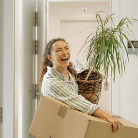 fille souriante avec un carton d'emménagement