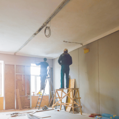 deux hommes en train de faire des travaux dans un appartement